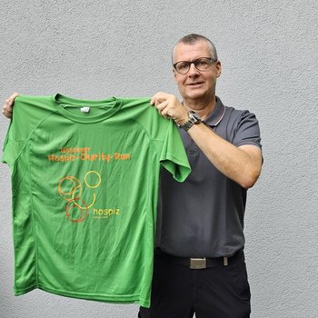 Ein solches Funktionsshirt, wie D. Martin Schencking, der Vorsitzende des Fördervereins Stationäres Hospiz Rhein-Lahn, es hier zeigt, erhalten alle Läuferinnen und Läufer über 10 und 5 Kilometer beim 6. Nassauer Hospiz-Charity-Run. Foto: Ariane Schencking