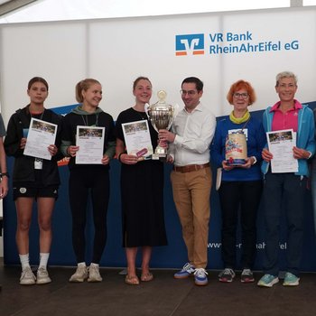 Philipp Hergarten als Beigeordneter der VG Brohltal überreicht den Wanderpokal an die schnellste Frauenmannschaft von der LG Rhein-Wied (Foto: Wolfgang Büsch)