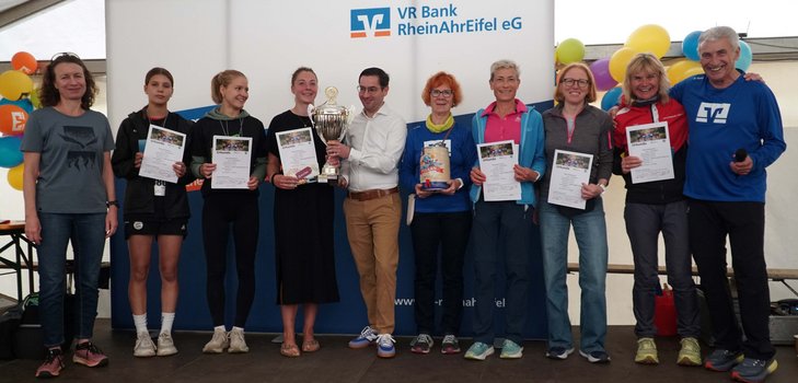 Philipp Hergarten als Beigeordneter der VG Brohltal überreicht den Wanderpokal an die schnellste Frauenmannschaft von der LG Rhein-Wied (Foto: Wolfgang Büsch)